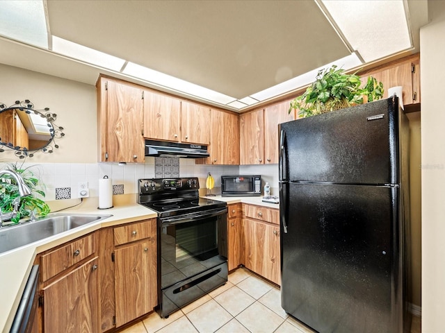 kitchen featuring black appliances, decorative backsplash, light tile patterned flooring, and sink