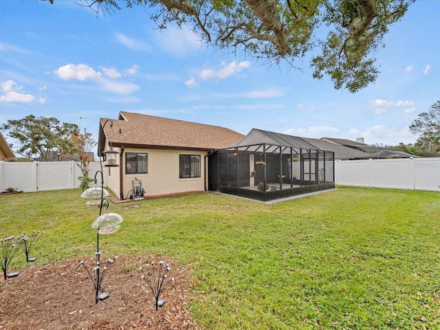 back of property with a lawn and glass enclosure