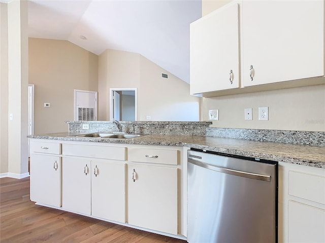 kitchen with lofted ceiling, white cabinets, dishwasher, and sink