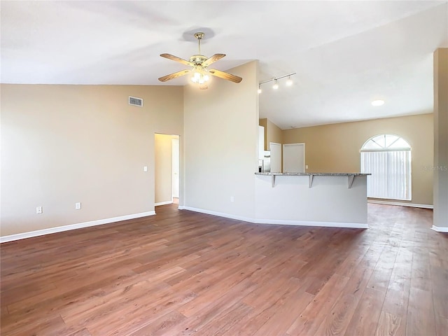 unfurnished living room with lofted ceiling, ceiling fan, rail lighting, and wood-type flooring