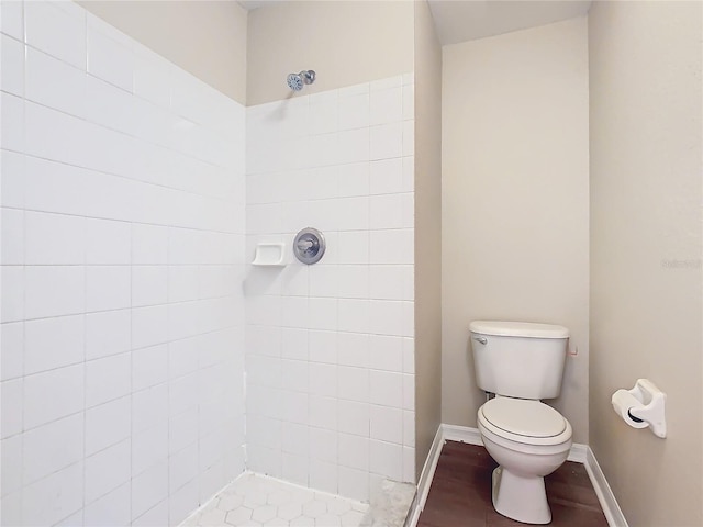 bathroom featuring toilet, tiled shower, and hardwood / wood-style flooring