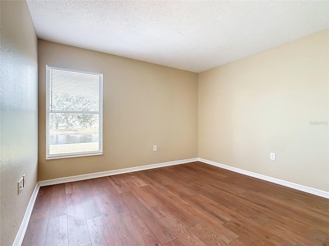 spare room with hardwood / wood-style flooring and a textured ceiling