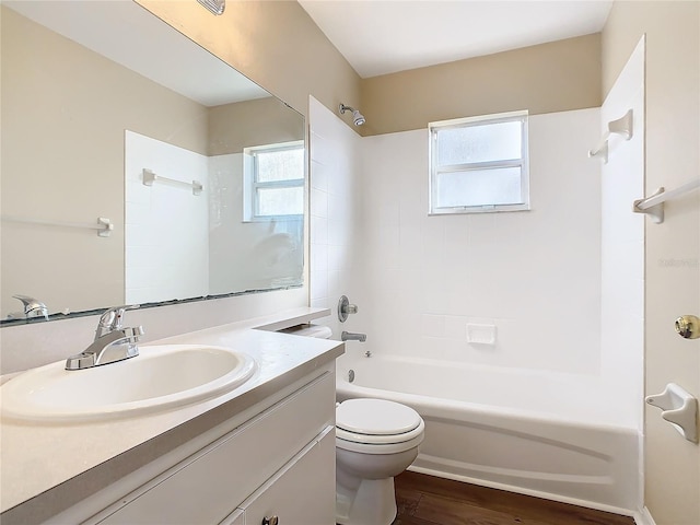 full bathroom featuring hardwood / wood-style flooring, tub / shower combination, toilet, and vanity