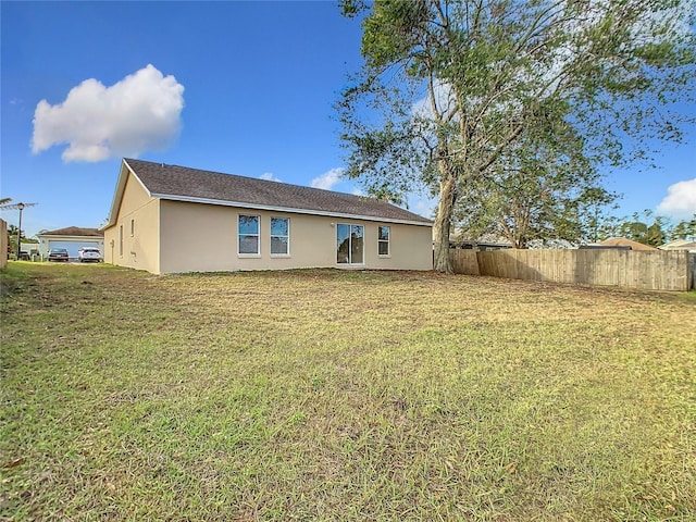 rear view of property with a lawn