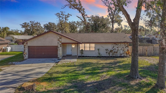 ranch-style home with a garage and a lawn