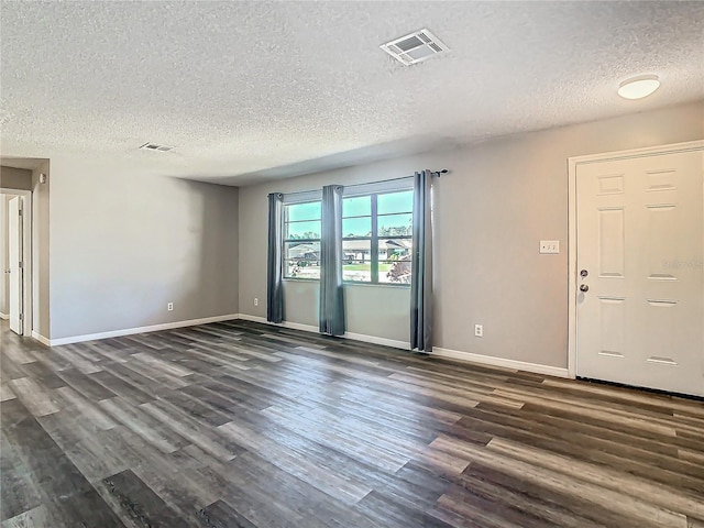 unfurnished room featuring a textured ceiling and dark hardwood / wood-style flooring