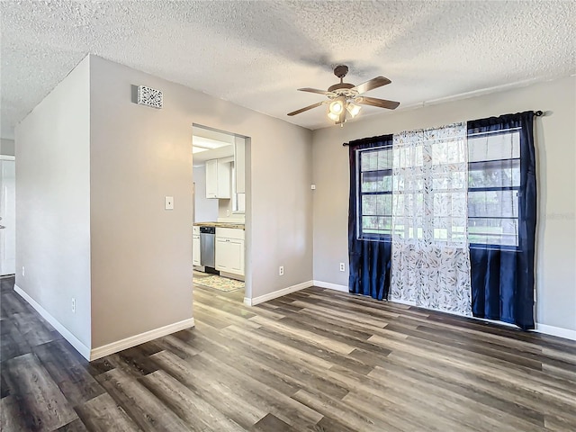 spare room featuring ceiling fan, dark hardwood / wood-style flooring, and a textured ceiling