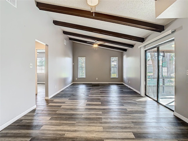 spare room with lofted ceiling with beams, dark hardwood / wood-style floors, ceiling fan, and a healthy amount of sunlight