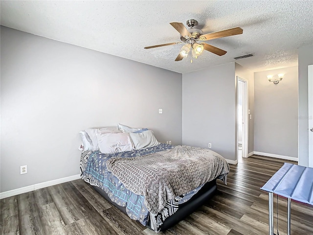 bedroom with ceiling fan, dark hardwood / wood-style floors, and a textured ceiling