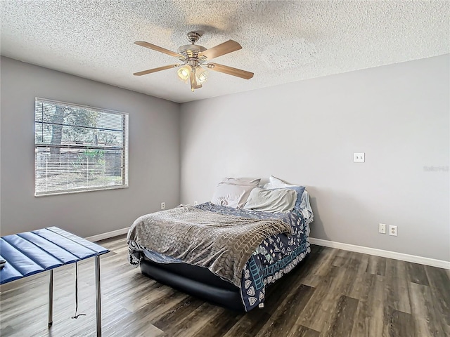 bedroom with a textured ceiling, ceiling fan, and dark wood-type flooring