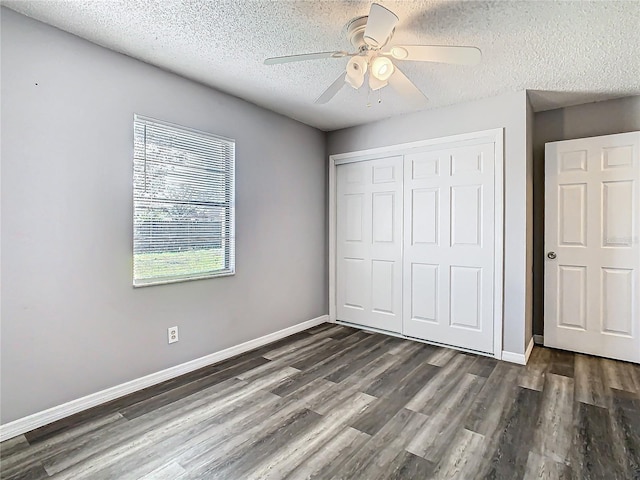 unfurnished bedroom with dark hardwood / wood-style flooring, a textured ceiling, a closet, and ceiling fan