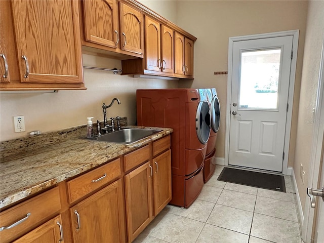 laundry room featuring sink, cabinets, light tile patterned flooring, and washer and dryer