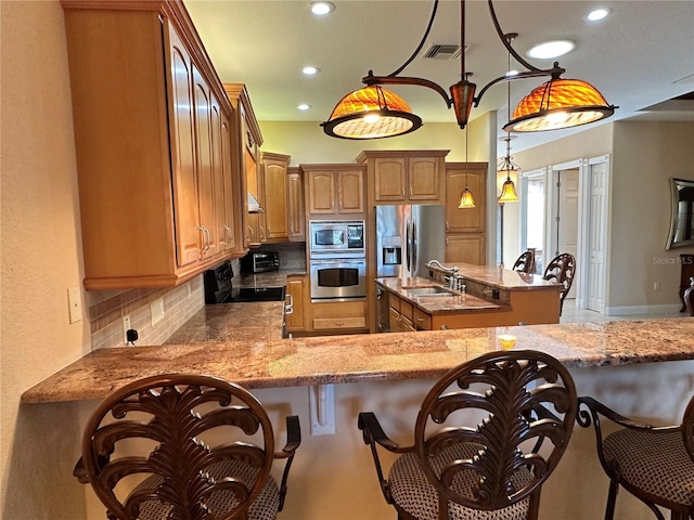 kitchen featuring sink, backsplash, a center island, stainless steel appliances, and hanging light fixtures