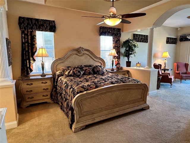 bedroom featuring decorative columns, light colored carpet, and ceiling fan