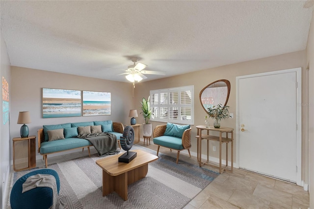 living room with ceiling fan and a textured ceiling