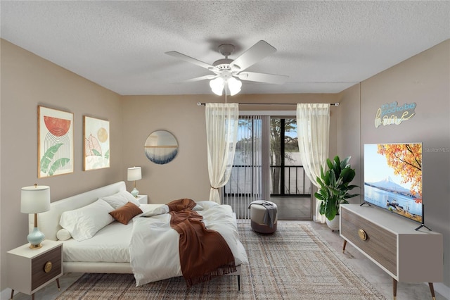 bedroom with a textured ceiling, a ceiling fan, and access to exterior