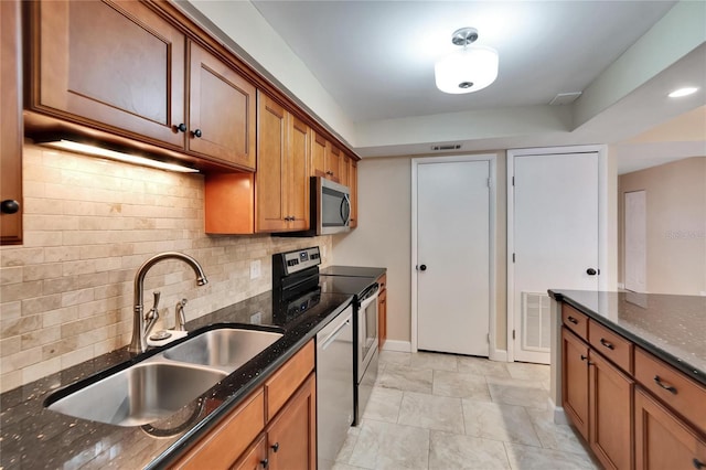 kitchen with tasteful backsplash, sink, dark stone counters, and stainless steel appliances