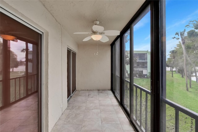 unfurnished sunroom with ceiling fan