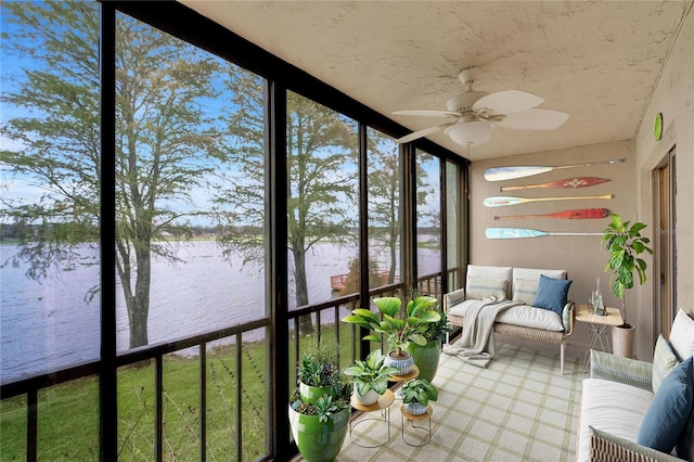 unfurnished sunroom with ceiling fan and a water view