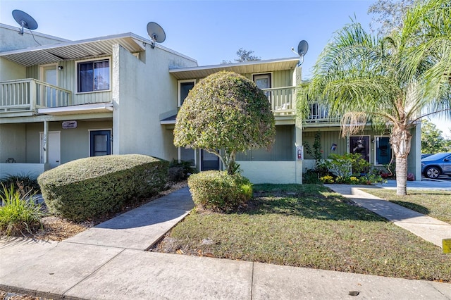 multi unit property featuring a front yard and a balcony