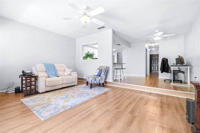 living room featuring ceiling fan and light hardwood / wood-style floors