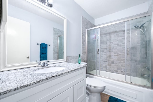 full bathroom with vanity, toilet, and enclosed tub / shower combo