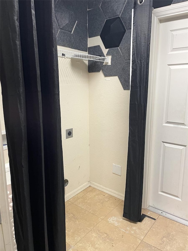 laundry room featuring electric dryer hookup and light tile patterned floors