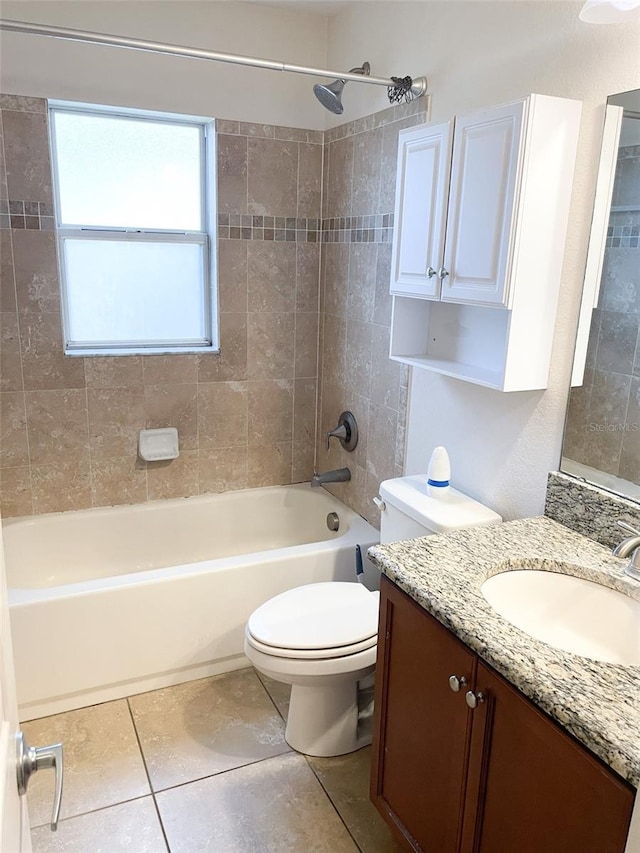 full bathroom with toilet, tile patterned flooring, tiled shower / bath, and vanity