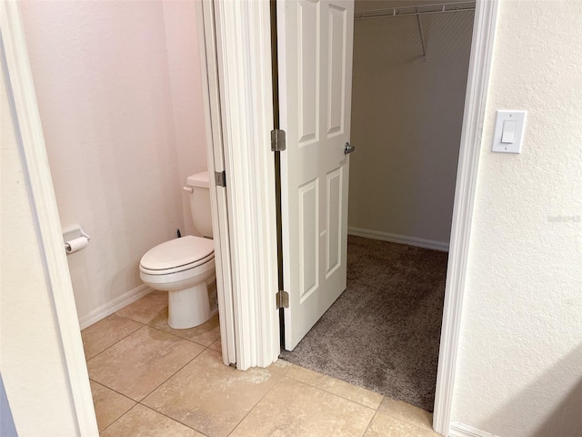 bathroom with toilet and tile patterned flooring