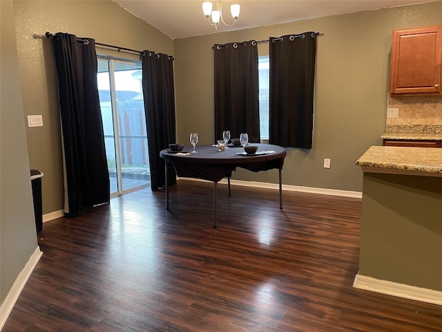 dining area featuring lofted ceiling, a notable chandelier, and dark hardwood / wood-style floors