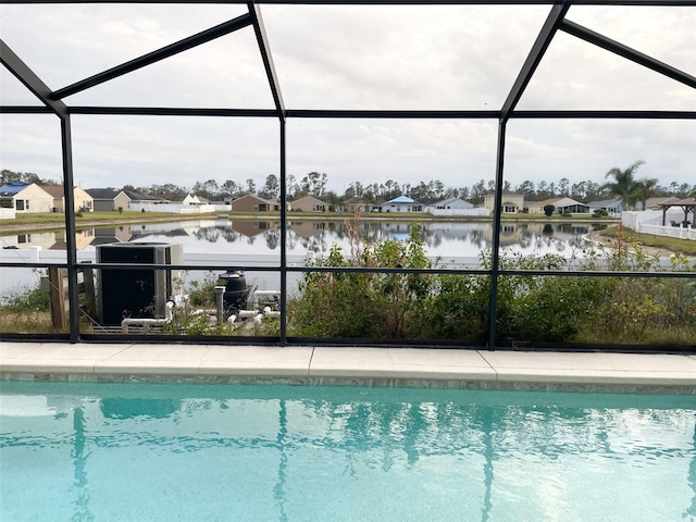 view of pool featuring a lanai and a water view