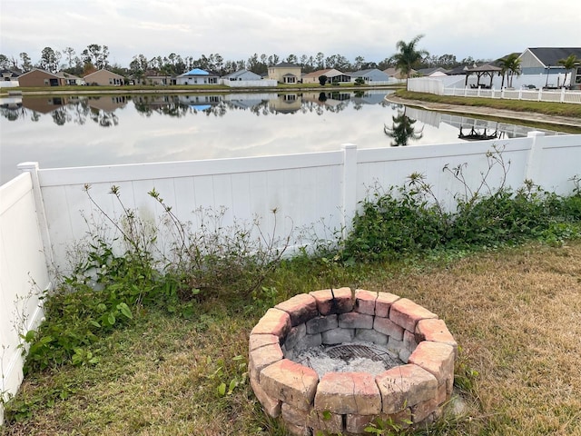 view of yard with a water view and an outdoor fire pit