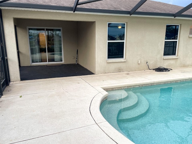 pool with glass enclosure and a patio