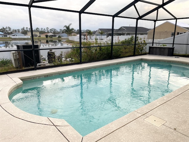 pool featuring a water view, glass enclosure, a patio area, and a residential view