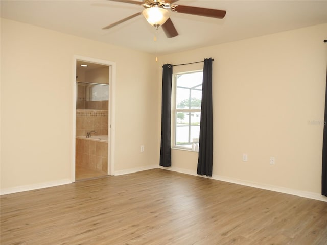 empty room with light wood-style floors, baseboards, and ceiling fan