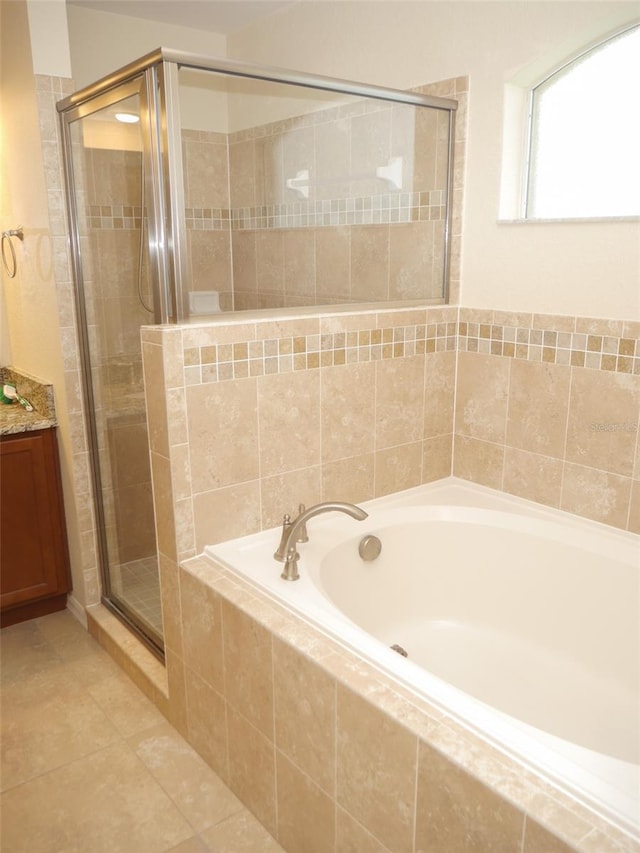 bathroom featuring a garden tub, vanity, tile patterned floors, and a shower stall