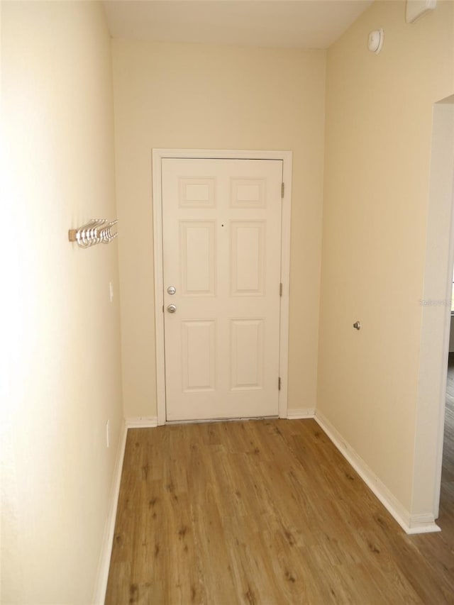 hall with baseboards and wood finished floors