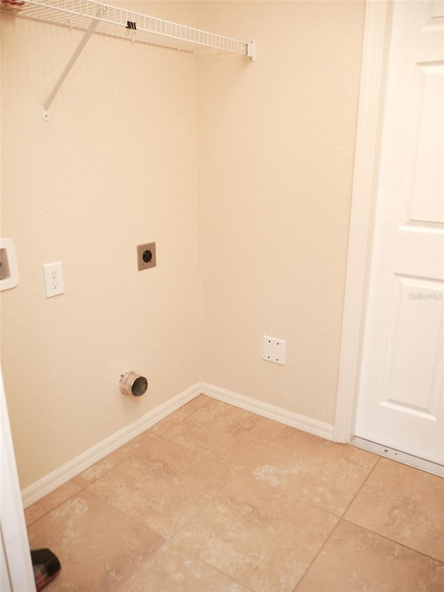 laundry area featuring electric dryer hookup, laundry area, baseboards, and light tile patterned floors