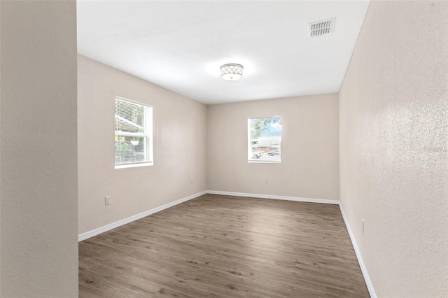 unfurnished room with dark wood-type flooring and a healthy amount of sunlight