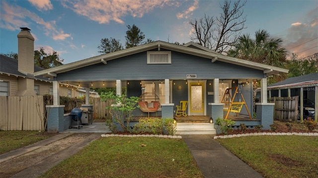 view of front of house with a lawn and covered porch