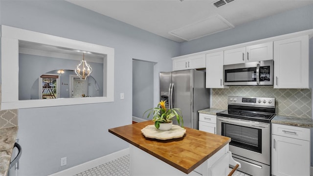 kitchen featuring white cabinets, pendant lighting, stainless steel appliances, and tasteful backsplash