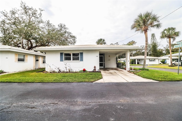 ranch-style house featuring a front lawn and a carport