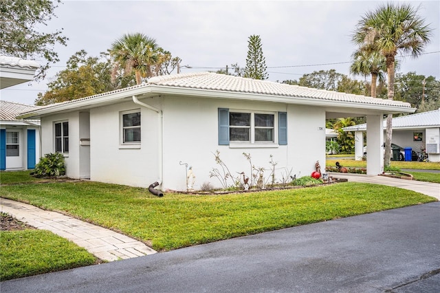 view of front of property with a front lawn and a carport