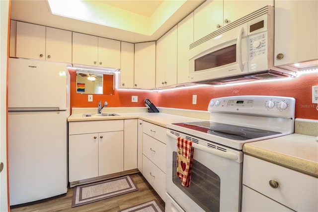 kitchen with white appliances, dark wood-type flooring, and sink