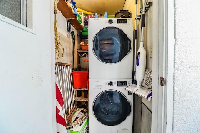 laundry room featuring stacked washer / drying machine