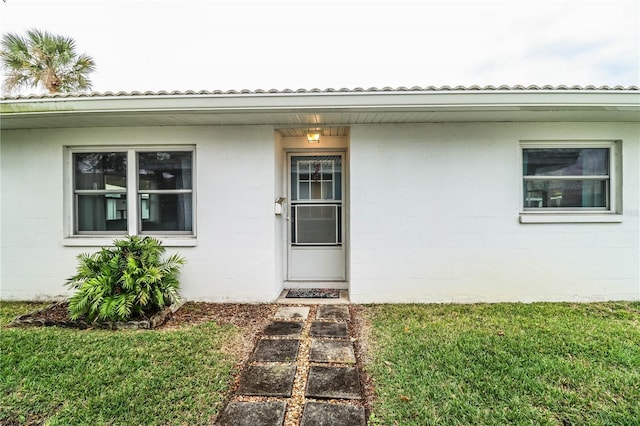 entrance to property featuring a yard