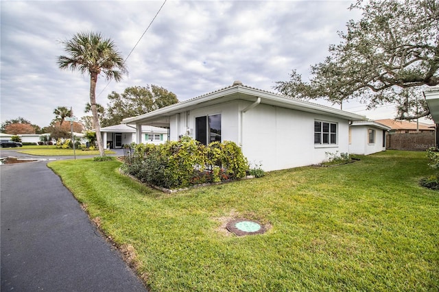 view of home's exterior featuring a yard and a carport