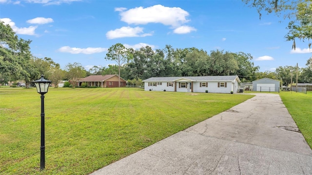 ranch-style house featuring an outbuilding, a garage, and a front lawn