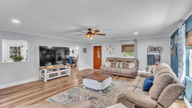 living room with light hardwood / wood-style flooring, ceiling fan, and crown molding