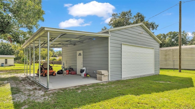 view of outdoor structure featuring a yard, a carport, and a garage